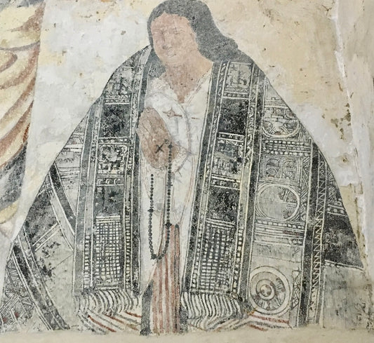 Painted mural of a cacique preying with an Indigenous cloth in Sutatausa